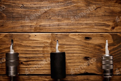 Preview: Three tattoo guns arranged on a brown wooden table