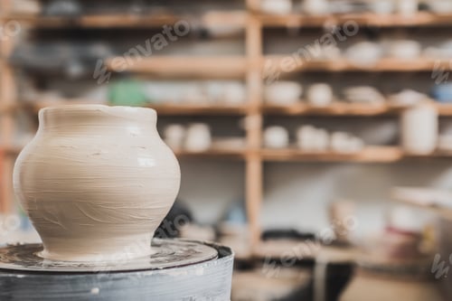 Preview: wet clay pot on pottery wheel on wooden bench in art studio