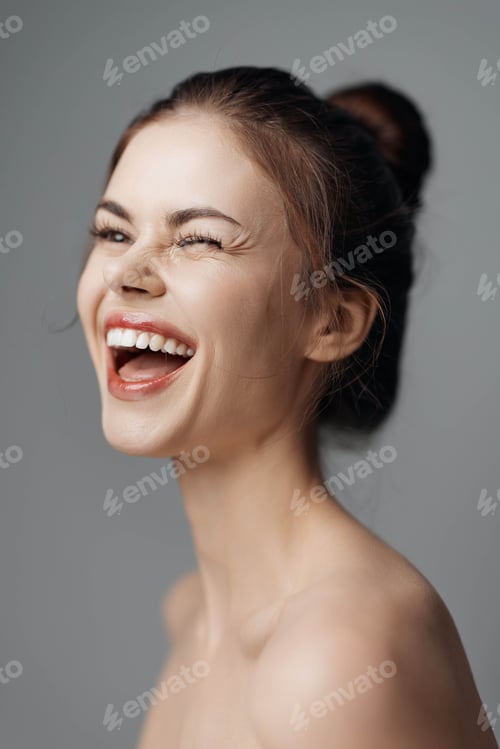 Preview: Happy woman laughing with mouth open, gray background