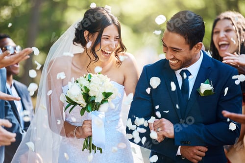 Preview: Guests throwing confetti over bride and groom as they walk past after their wedding ceremony. Joyfu