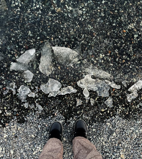 Preview: Woman standing next to the ice in the glacier lagoon in Iceland