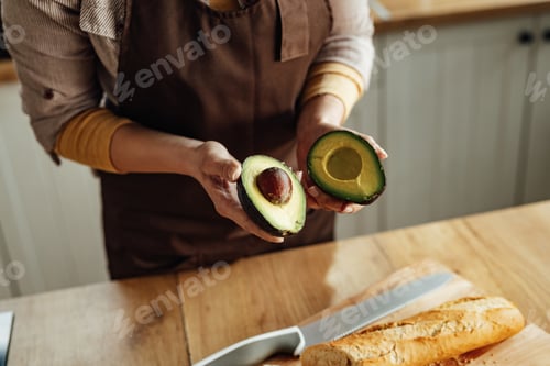 Preview: Close-up of woman using avocado while preparing food in the kitchen.