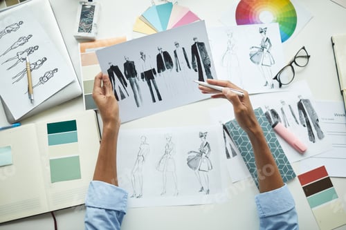 Preview: Designer examining sketches of clothes