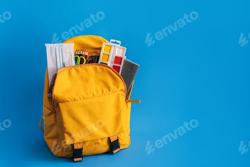 Preview: Yellow backpack with school supplies on blue background