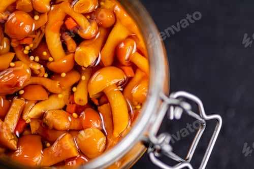 Preview: Fragrant pickled mushrooms in a glass jar.
