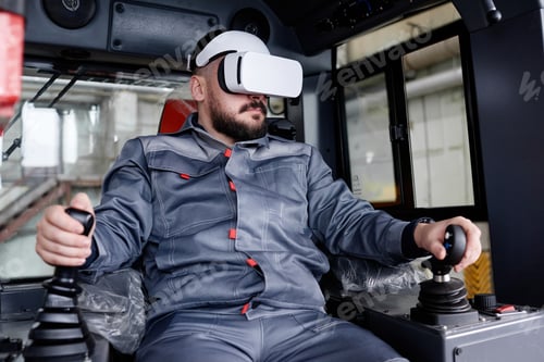 Preview: Confident male builder in vr headset holding by gearshifts while driving machine