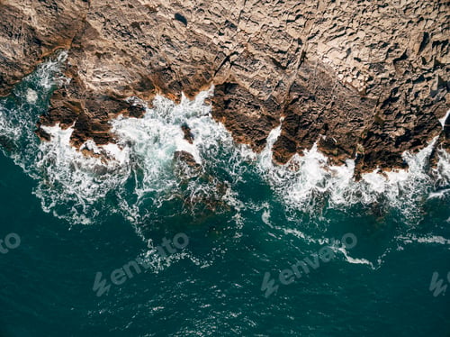Preview: Aerial drone, top view of the beautiful ocean waves, crashing on the coast of a rocky island.