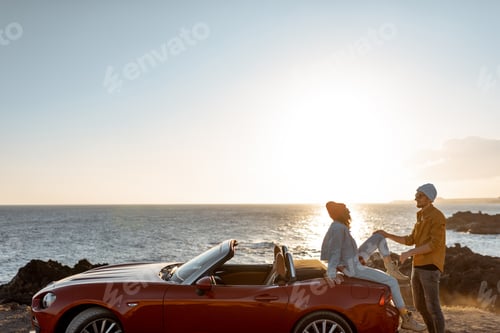 Preview: Lovely couple on the beach near the car on a sunset