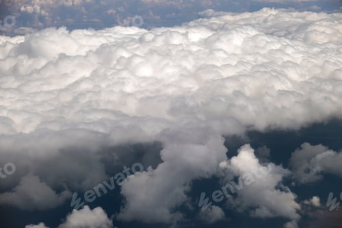 Preview: Aerial view from airplane window of white puffy clouds on bright sunny day