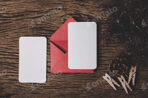 Preview: Two blank card with red envelope and Clothespin is placed on wood.