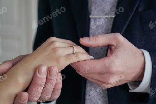 Preview: Man holding woman's hand with engagement ring, wedding day
