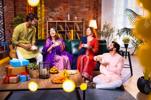 Preview: Drinking tea during Diwali with Indian relatives and friends at decorated indoor festive home
