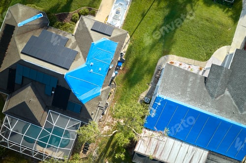 Preview: Top view of leaking house roofs covered with protective tarp sheets against rain water