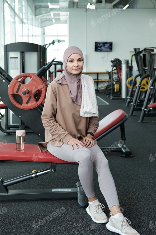 Preview: Restful Muslim woman in sportswear resting after training