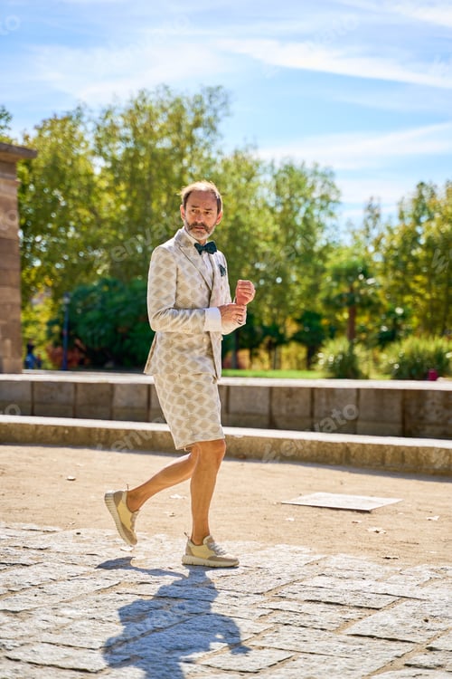 Preview: Stylish Man Walks Through City Park in Suit