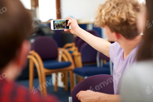 Preview: Male and female higher education students taking selfie in college classroom