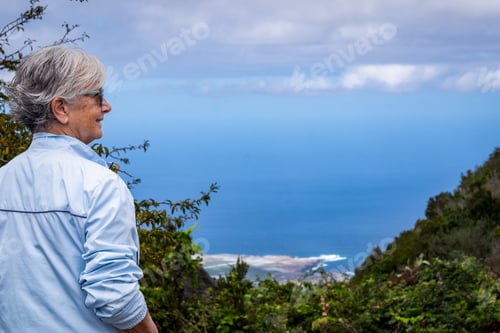 Preview: Mature gray haired woman in outdoor excursion between mountain and sea