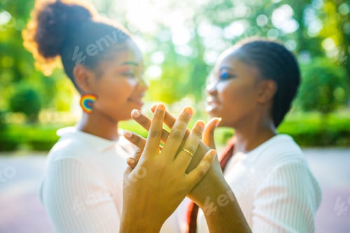 Preview: brazilian lesbian couple in white dress spending time together celebrating engagement in summer park