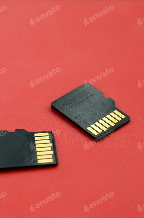 Preview: Two small micro SD memory cards lie on a red background