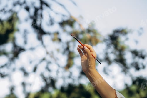 Preview: artist holding a paint brush close-up