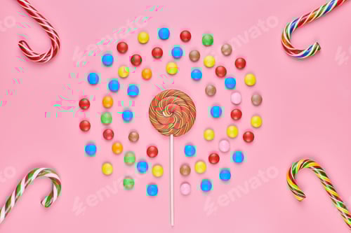 Preview: Sweet lollipops and candy canes on pink background