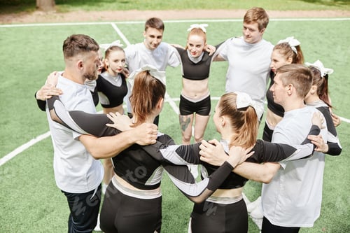 Preview: Cheerleader team standing in circle with coach