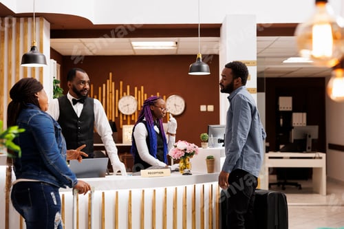 Preview: Tired tourists at hotel front desk