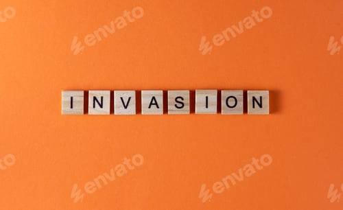 Preview: Invasion word phrase in wooden letters. Motivation and slogan. Orange background