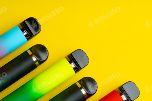 Preview: Colorful disposable electronic cigarettes on yellow background
