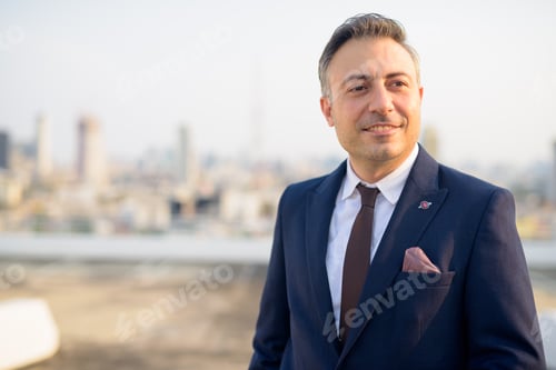 Preview: Face of happy mature businessman thinking against view of the city