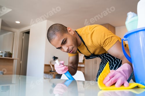 Preview: Young latin man cleaning at home.