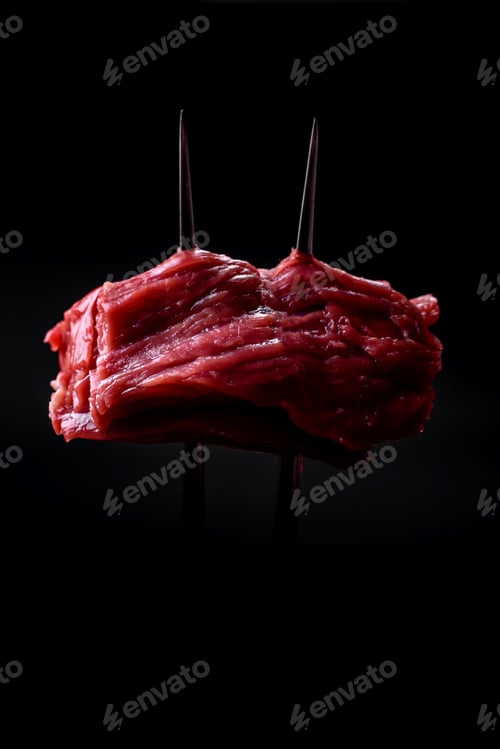 Preview: Raw beef cut into several pieces on a wooden cutting board