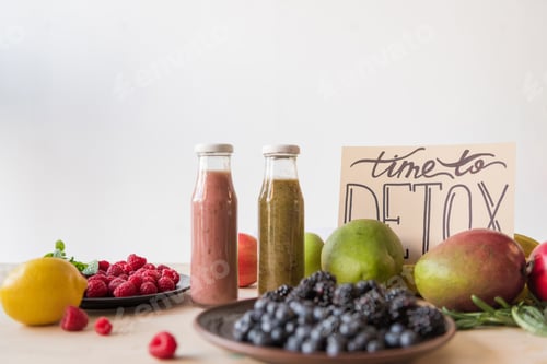 Preview: close up view of detox drinks, time to detox card and organic food on wooden tabletop
