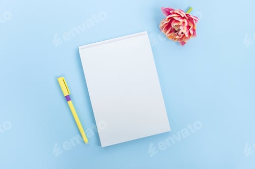 Preview: Top view of a blue table with a mockup of blank notebooks and a pen with a bouquet of tulips .