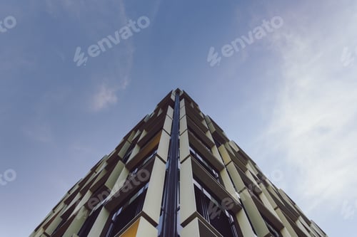 Preview: Low angle view of a modern building under the sunlight and a blue sky