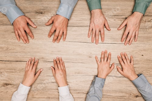 Preview: Top view of businesspeople with hands on wooden table, cropped view