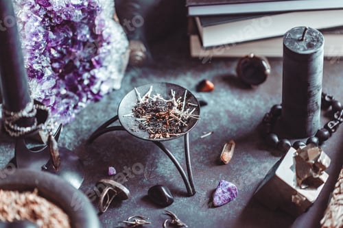 Preview: Smoked herbs on a witch's altar for a magical ritual among crystals and black candles.