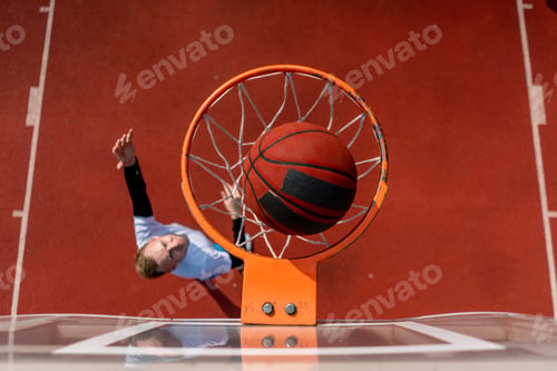 Preview: Close-up of basketball ring into which tall guy basketball player throws the ball