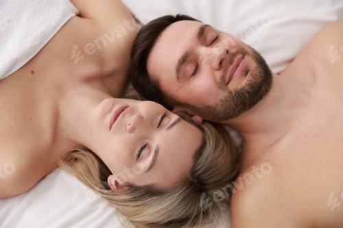 Preview: Spa. Happy couple lying on bed, above view
