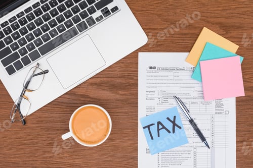 Preview: top view of tax form, coffee, laptop and blue card with 'tax' word on desk