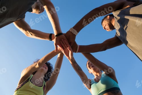 Preview: View from below of a group of sporty people in a huddle