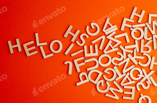 Preview: wooden cut alphabet letters on orange background spelling the word hello