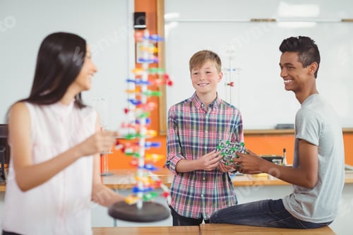 Preview: Happy school kids experimenting molecule model in laboratory