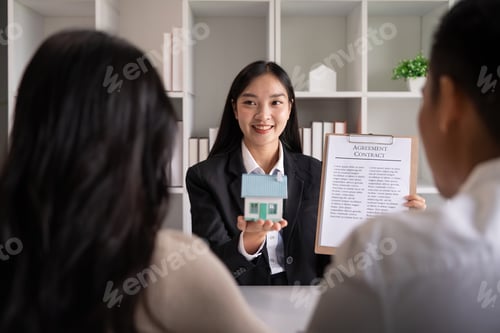 Preview: Young married couple sitting at table listening to realtor, real estate agent, loan broker or