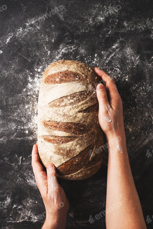 Preview: Bakery concept with bread and man hands on black background