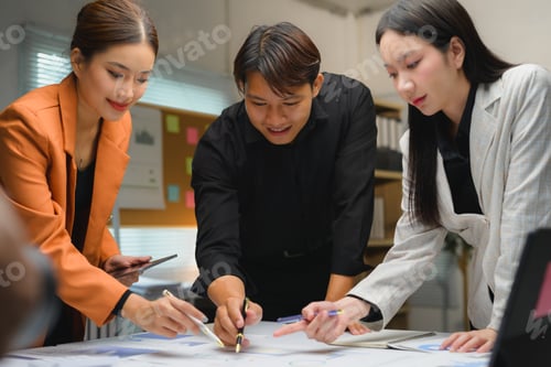 Preview: Asian businesspeople analyzing financial charts and discussing project strategy