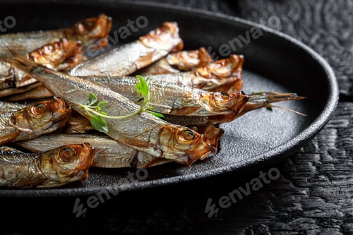 Preview: Tasty and salty smoked sprats on white food paper.