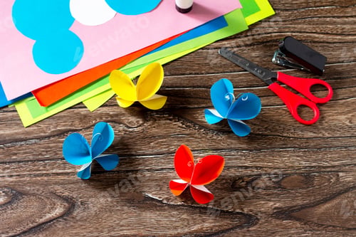 Preview: Butterfly paper decor or summer garland on a wooden table.