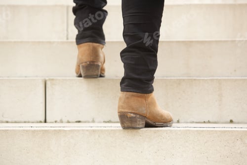 Preview: rear view of man walking up stairs in boots