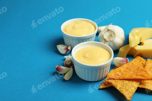 Preview: Cheese sauce, ingredients and chips on blue background